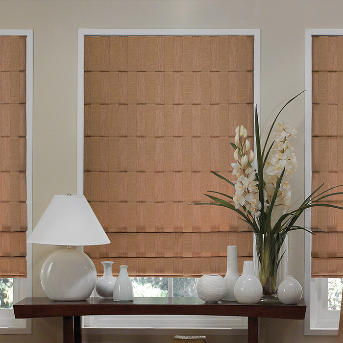 Tan Roman shades in a bedroom.