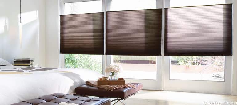 Minimal Cincinnati bedroom with high ceiling windows and vertical cellular shades.