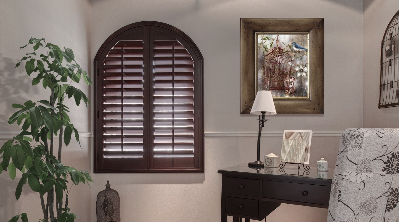 Arched wood shutters in bedroom