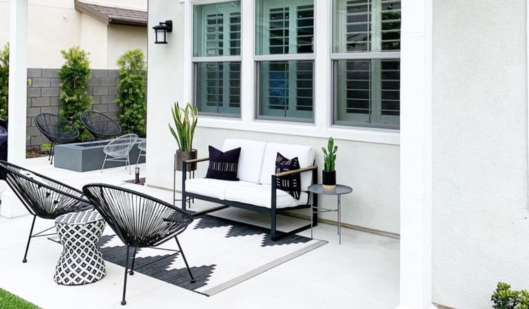 Spending a little time mulching and weeding can help give you a backyard oasis. An outside patio with plantation window treatments