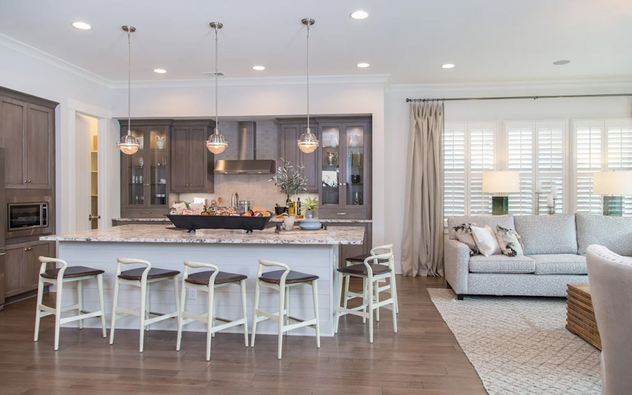 Illuminate your home with custom interior shutters in Cincinnati. White arched shutters in a white kitchen with lots of light.