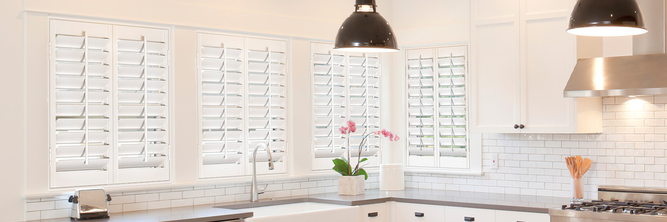 White Polywood shutters above a modern kitchen sink