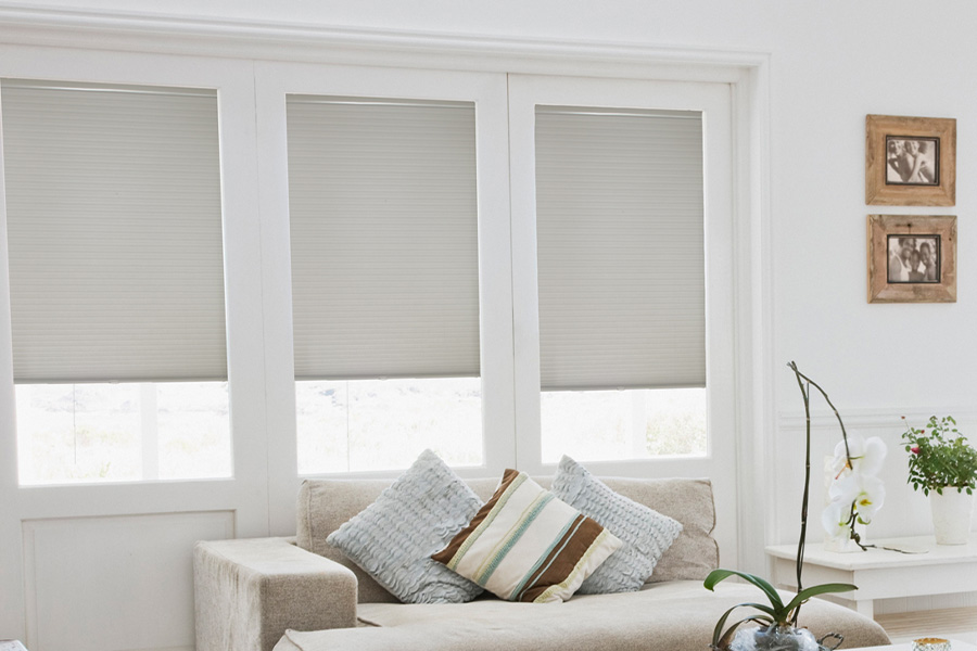 Light gray cellular shades inside a white and rustic styled living room.