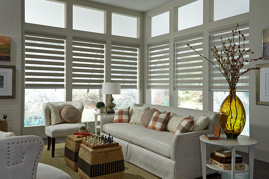 Gray transitional shades on a row of tall windows in a living room