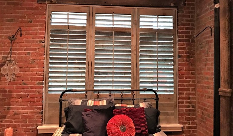Reclaimed wood shutters give an organic touch to your minimalist design. Reclaimed wood shutters surrounded by brick wall.