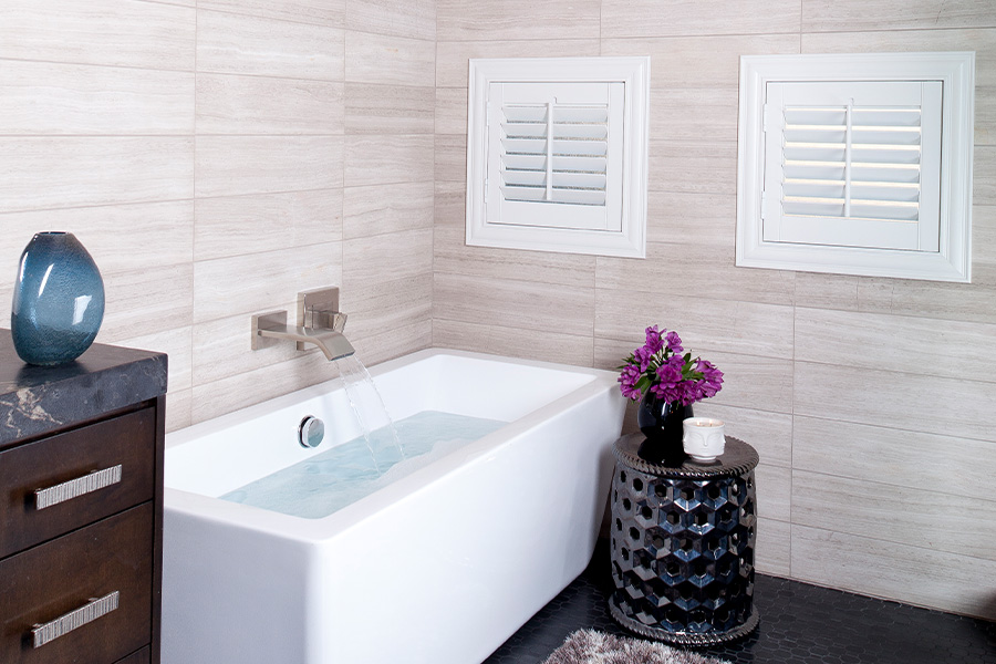 Plantation shutters are perfect for these bathroom casement windows as they provide privacy and ventilation. Two casement windows covered by plantation shutters in bathroom.