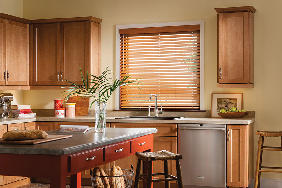 Waterproof faux wood blinds are durable and give you privacy and light control in your Cincinnati kitchen. Dark faux wood blinds above a kitchen sink