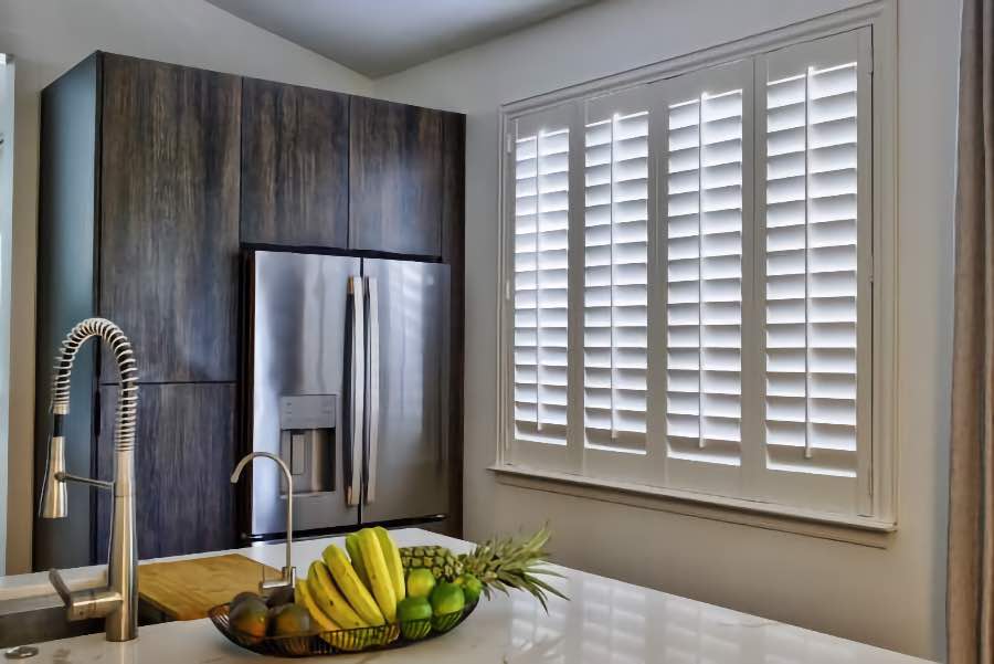 Homeowners use indoor window shutters in Cincinnati when they want attractive and functional window treatments. Polywood shutters on a large kitchen window