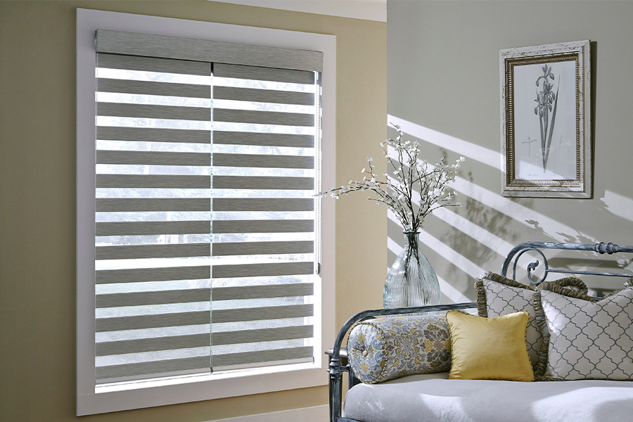 Find Practical and stylish window blinds for Cincinnati homes at Sunburst. Gray blinds on a large window next to a couch.