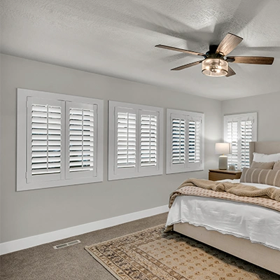 White polywood shutters in a large white bedroom